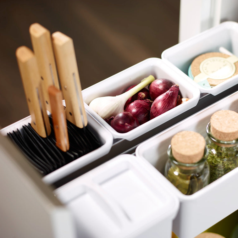 Offene Schublade mit ordentlich organisierten YouboXx Einhängeboxen - Set 1 für DISPENSA, die Küchenmesser, Gabeln, rote Zwiebeln, eine Knoblauchknolle, Gläser mit Korkdeckeln und einen kleinen Behälter mit einem Papieretikett enthält.