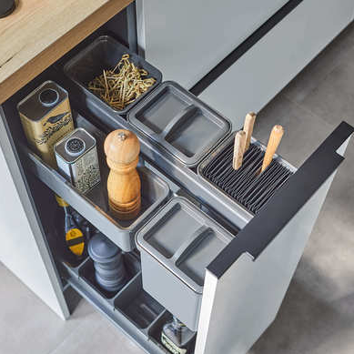 Eine Küchenschublade ist geöffnet und zeigt die übersichtliche Organisation der YouboXx Einhängeboxen Set 5 für DISPENSA Apothekerschränke mit Fächern für Messer, Pfeffermühle, Olivenölflaschen, Utensilien und goldene Büroklammern - alles mit einem modernen Touch.