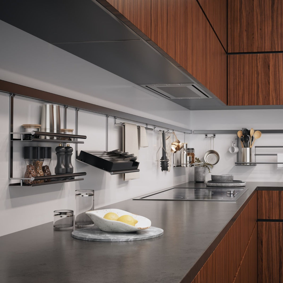 Moderne Küche mit Holzschränken, einer schlichten grauen Arbeitsplatte und Wandregalen mit dem Kesseböhmer Linero style Edelstahloptik Aluprofil (600-1800 mm) Küchen Relingsystem für Utensilien und Gewürze. Eine Schale mit Zitronen steht auf einem Marmortablett neben dem Herd.