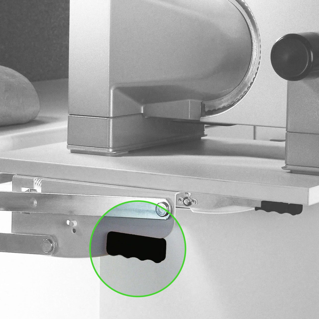 Die Nahaufnahme einer Aufschnittmaschine hebt einen wellenförmigen schwarzen Schlitz in der Halterung hervor - ideal für die Installation mit dem Handgriff für Parallel-Schwenkbeschlag.