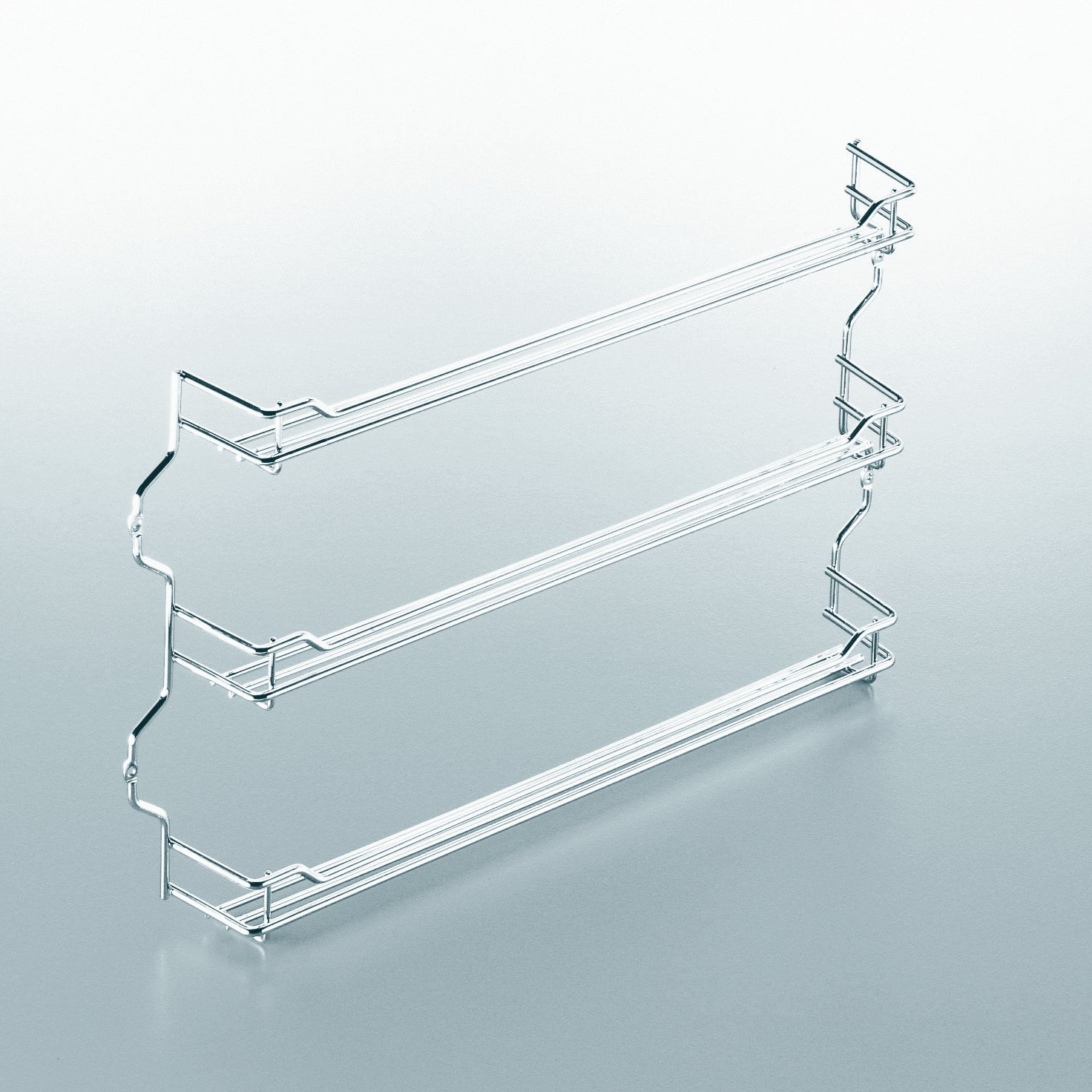 Das Gewürzregal für Schrank & Schranktür - Gewürzbord besteht aus drei silbernen Drahtgestellen mit seitlichen Stützen und ist eine minimalistische Aufbewahrungslösung für Gewürze, die sich von einem hellen Hintergrund abhebt.