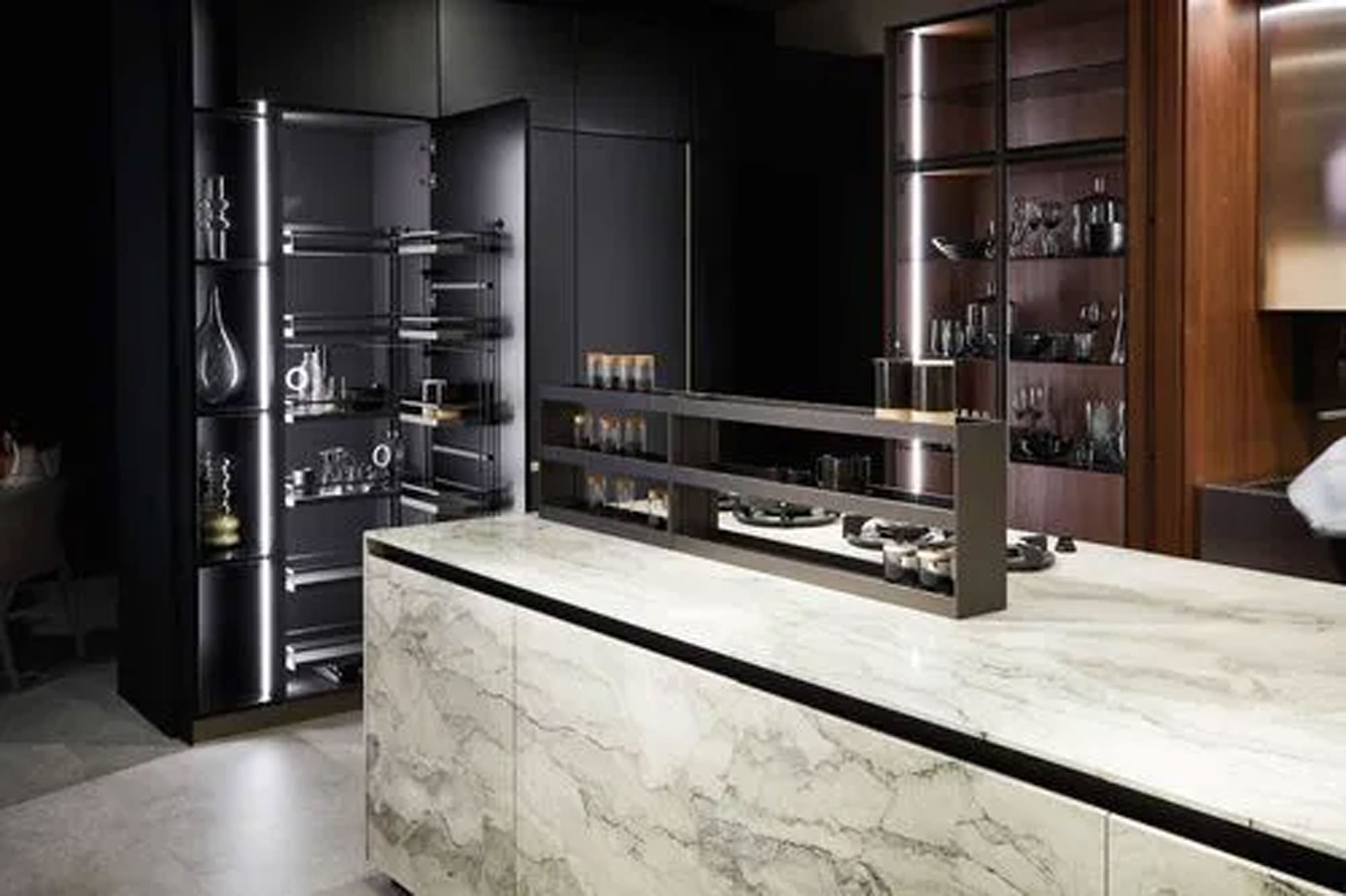 Moderne Küche mit einer Marmorinsel, eleganten schwarzen Schränken, Glasregalen für Glaswaren und integrierter Beleuchtung, die ein klares, zeitgemäßes Aussehen schaffen.