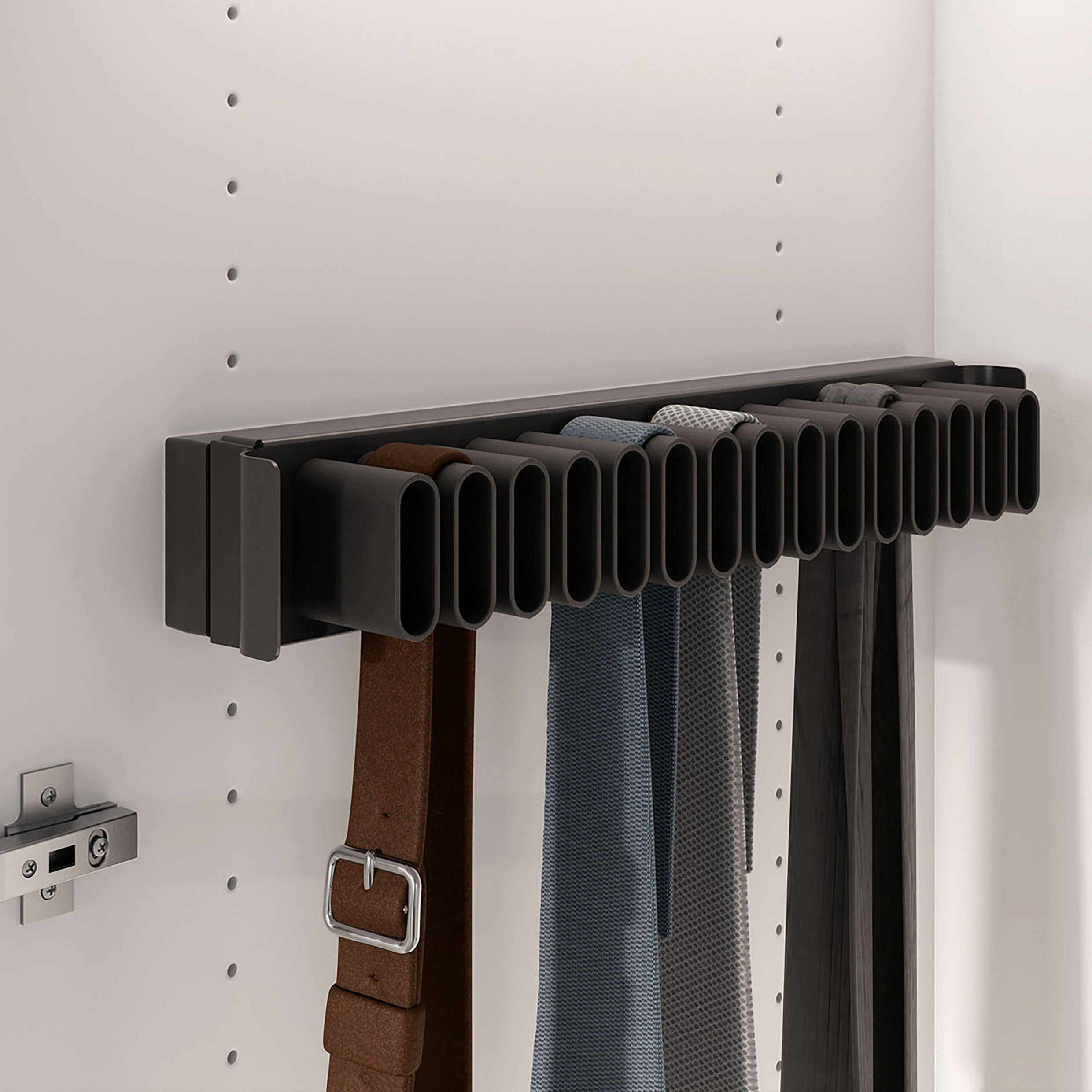 Der CONERO Gürtel- und Krawattenhalter (Auszug) ist an einer weißen Schrankwand montiert und hält drei Gürtel sowie zwei Krawatten ordentlich in ovalen Aussparungen - ideal für mehr Stauraum im Schrank.