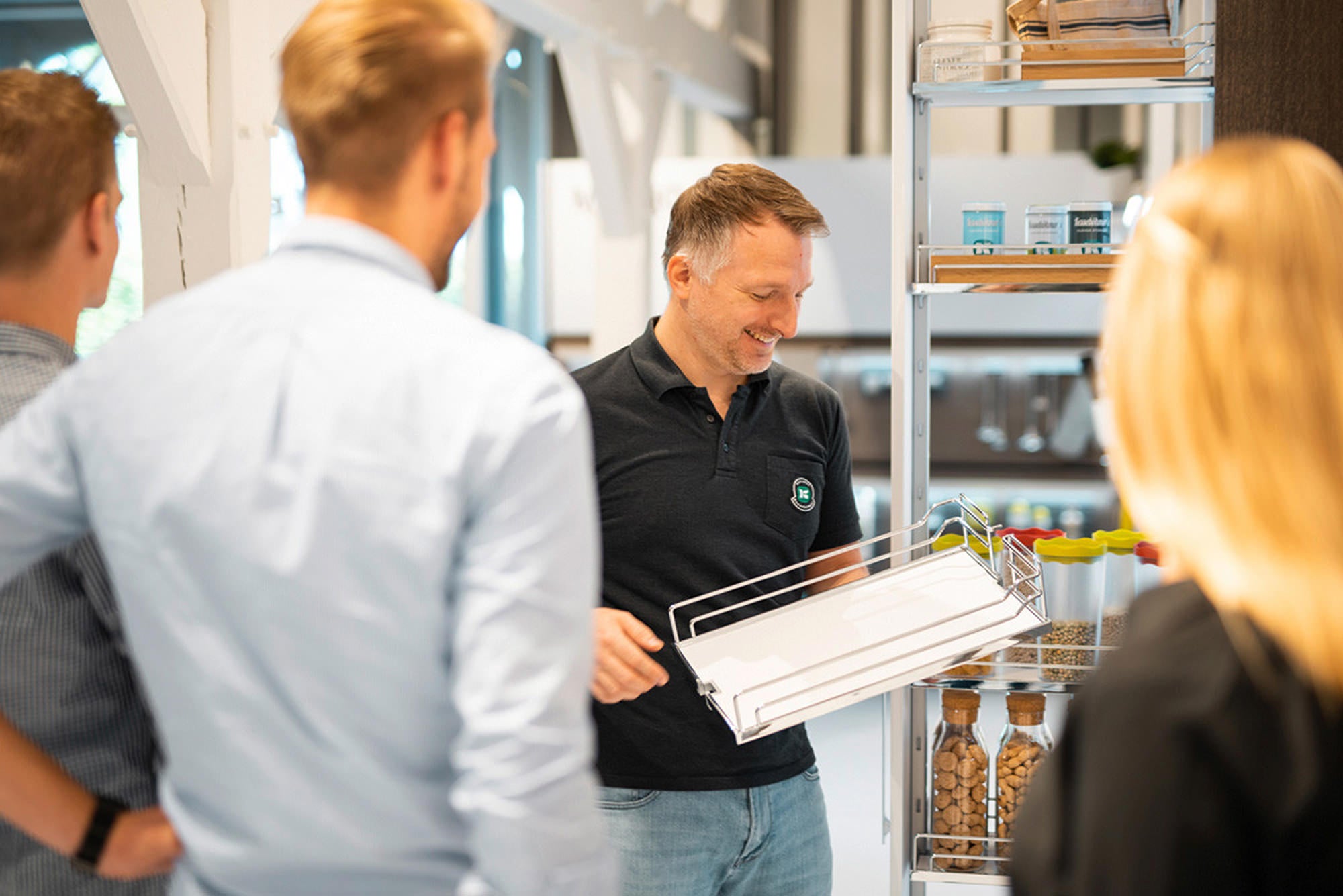 Mann erklärt Einhängeboden drei weiteren Personen.