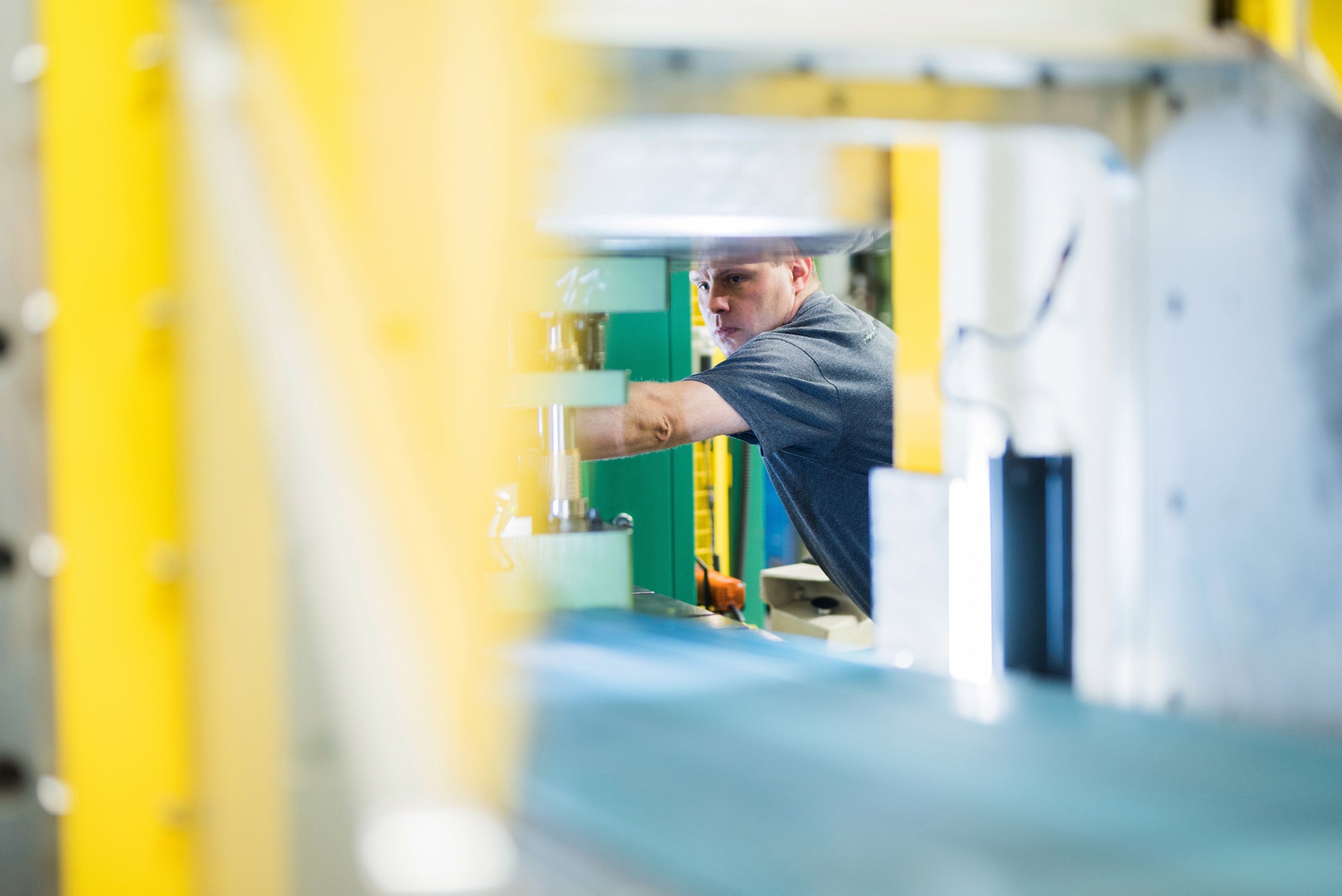 Arbeiter bedient Anlage mit Fließband.