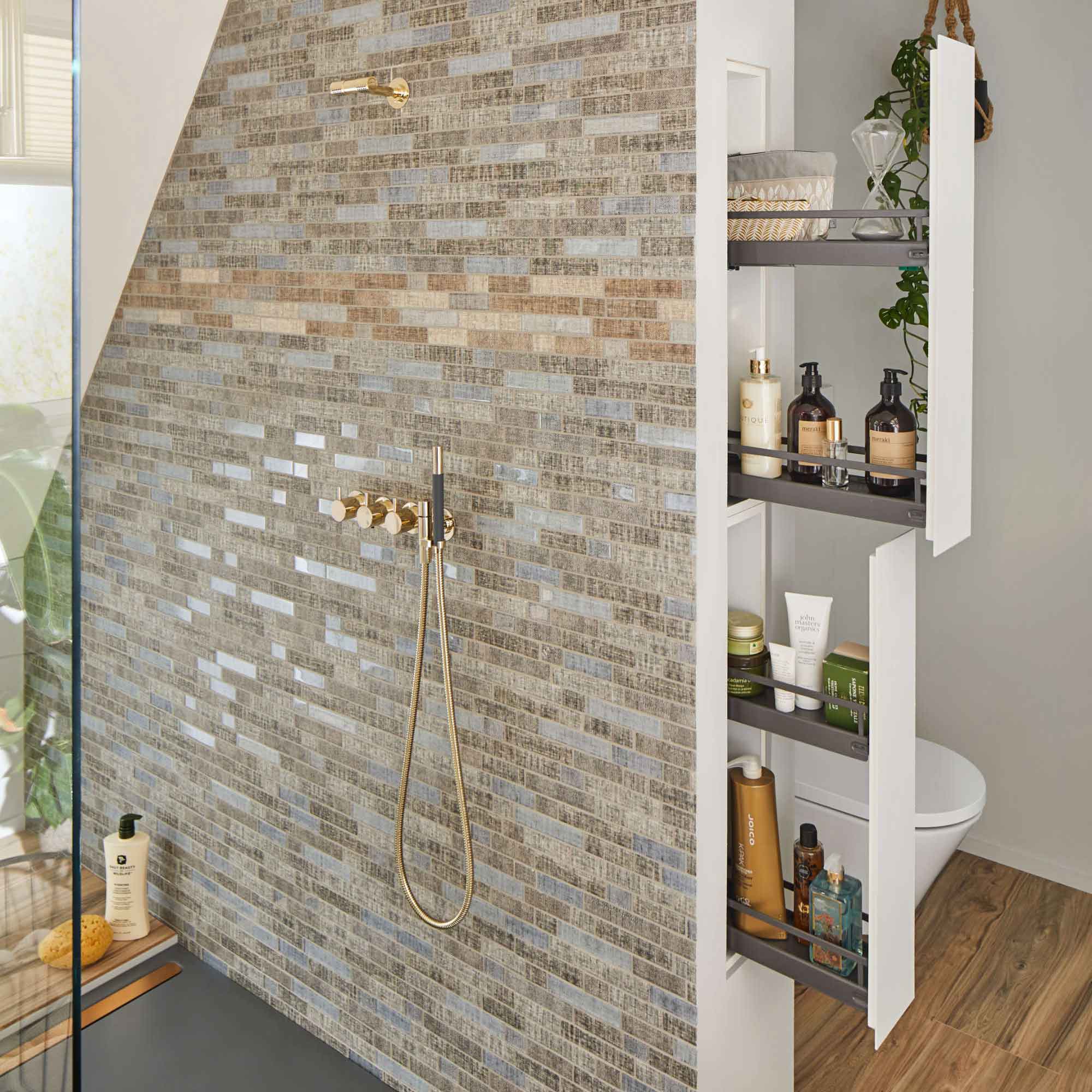 In die Schamwand neben der Toilette integrierte und übereinander angeordnete Auszüge in einem Badezimmer.