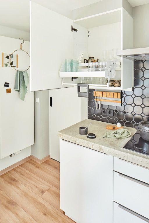 Weißes Auszugsystem im Hängeschrank wird nach unten geschwenkt mit Griff nach unten.