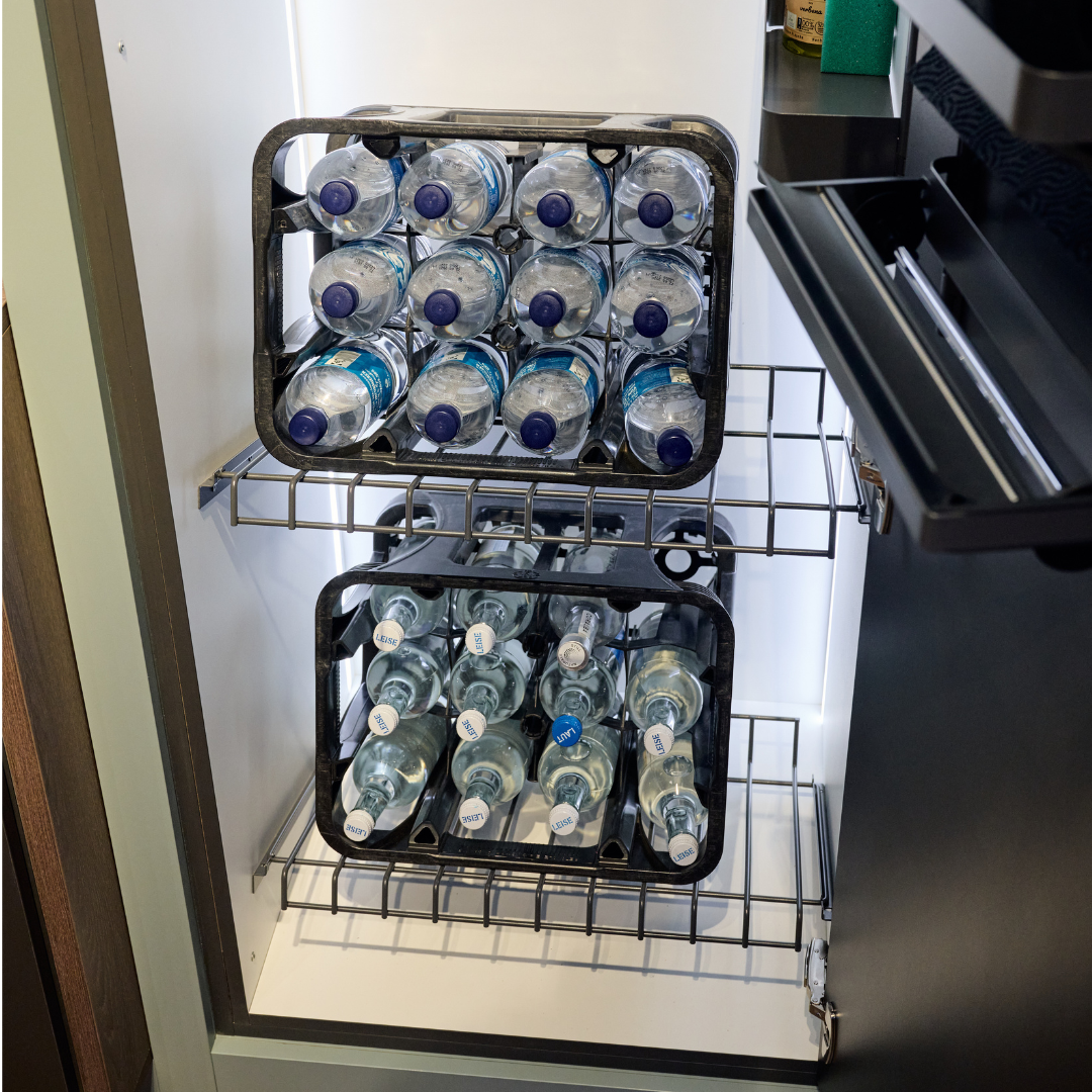 Zwei schwarze Ablage-Sets für Getränkekisten - 600 mm halten mehrere Wasserflaschen auf Metallkühlregalen. Das platzsparende Design hält Flaschen mit blauem Deckel organisiert, und das Set ist aus robusten Materialien hergestellt.