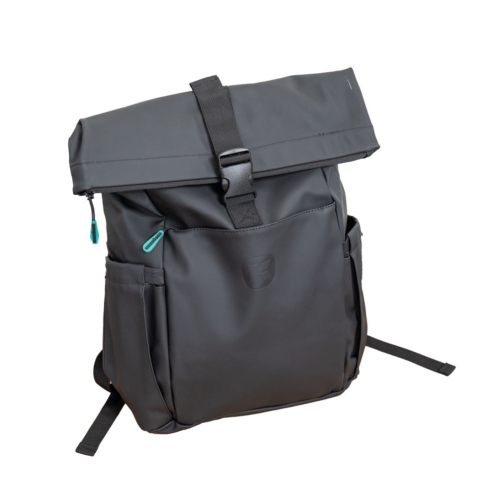 Der Kesseböhmer Rucksack ist eine schlichte schwarze Rolltop-Tasche mit dem Kesseböhmer-Logo, einer Schnalle auf der Vorderseite, Seitentaschen und tealfarbenen Reißverschlüssen - ein unverzichtbares Accessoire für den Alltag, das aufrecht auf weißem Grund steht.