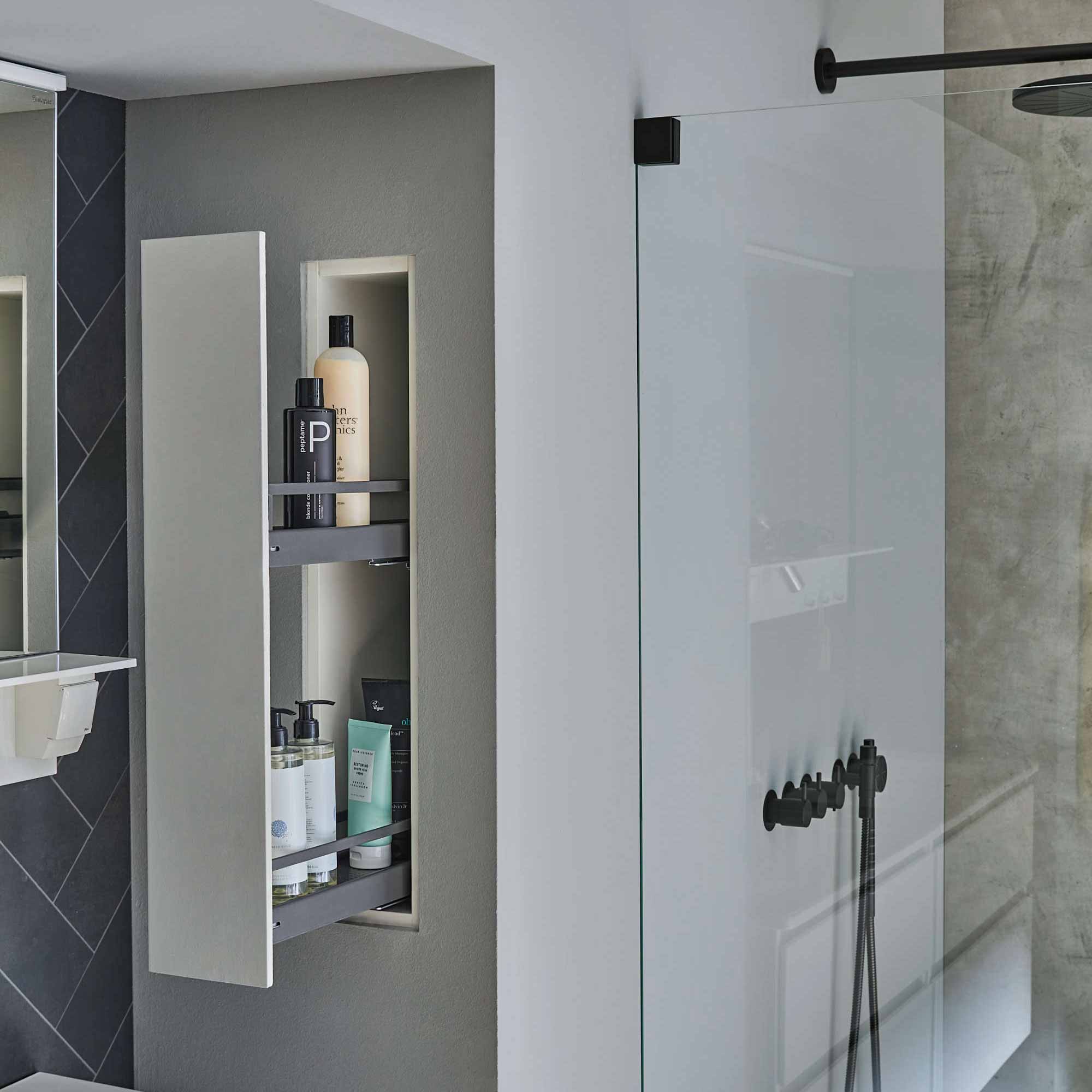 In der Wand neben der Dusche integrierter Auszug in ausgefahrenem Zustand.