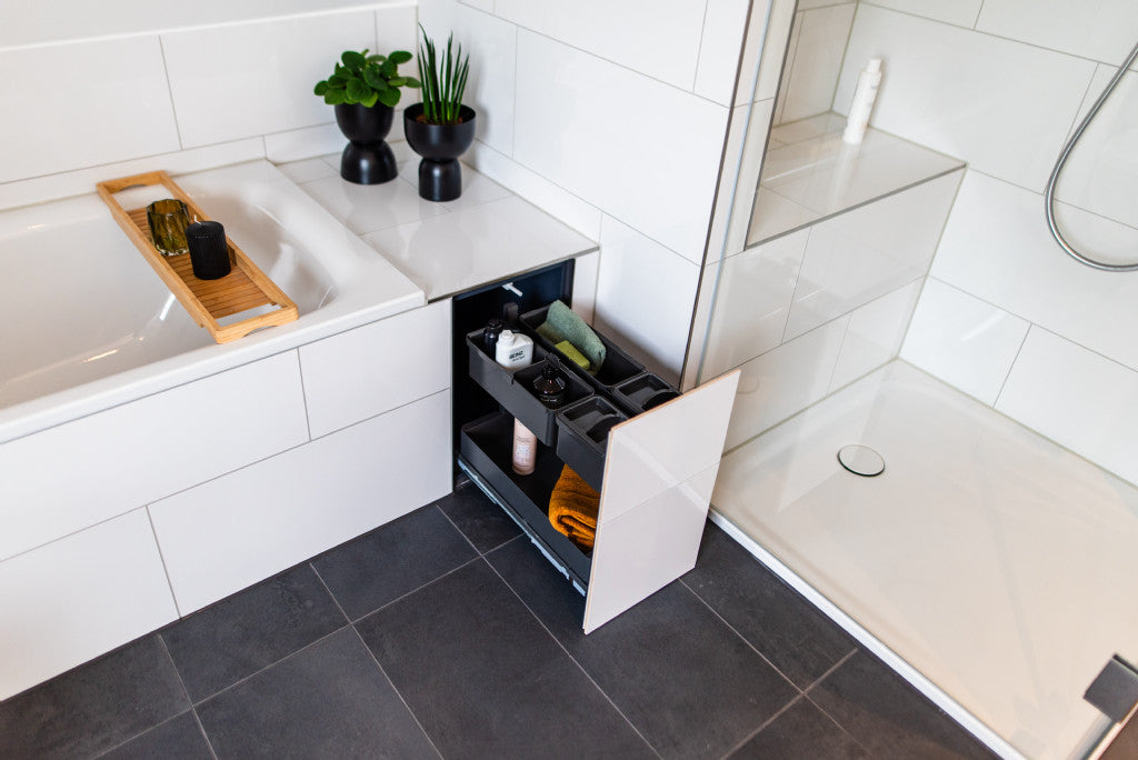 In die Badewanne integrierter Auszug im Badezimmer mit großen weißen Fliesen befliest.