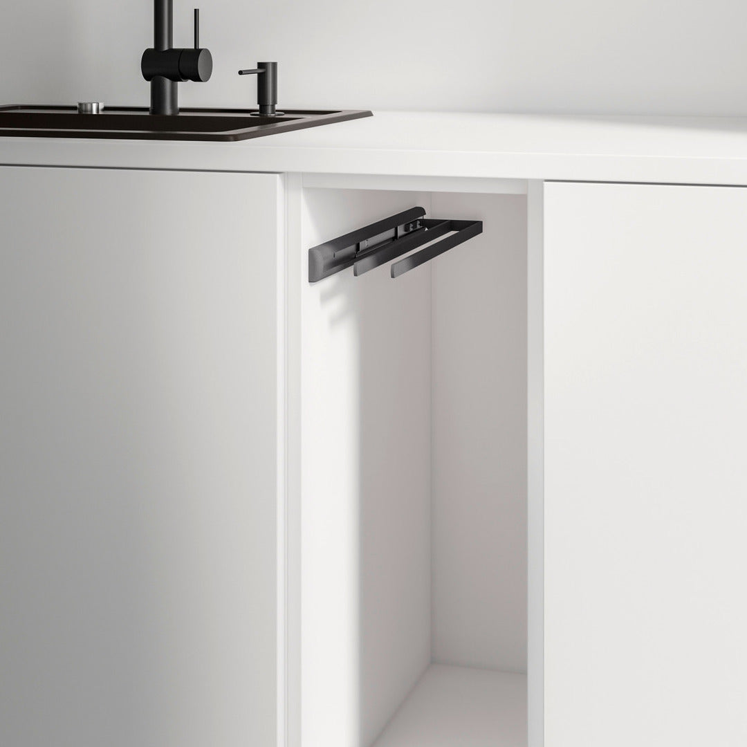 Eine moderne weiße Küche mit schwarzem Spülbecken und Wasserhahn. Aus dem leeren Unterschrank ist der Handtuchauszug 2-armig aus schwarzem Metall ausgezogen - eine platzsparende Lösung für Handtücher.