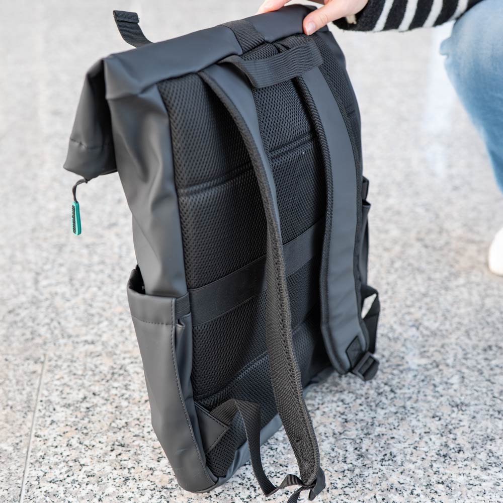 Eine Person in einem schwarz-weiß gestreiften Pullover hält einen Kesseböhmer-Rucksack mit Netzpolsterung und verstellbaren Trägern aufrecht auf einer gesprenkelten grauen Fläche - ideal für Mahlzeiten to go.