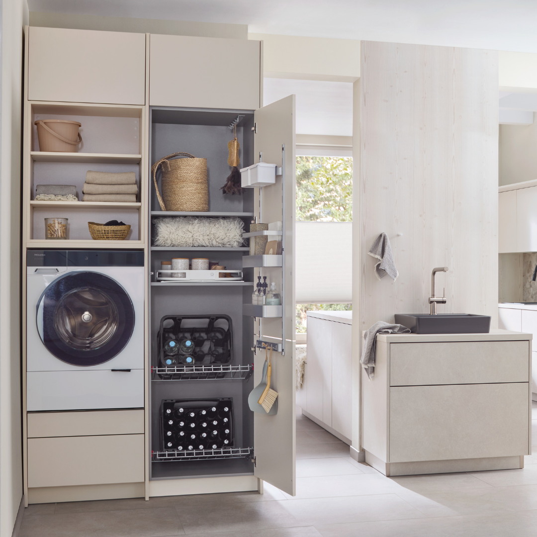 Eine moderne Waschküche mit offenen Regalen für Handtücher, Körbe und Reinigungsmittel. Der platzsparende Schrank verfügt über das Ablage-Set für Getränkekisten - 600 mm zur effizienten Lagerung von Getränkekisten.